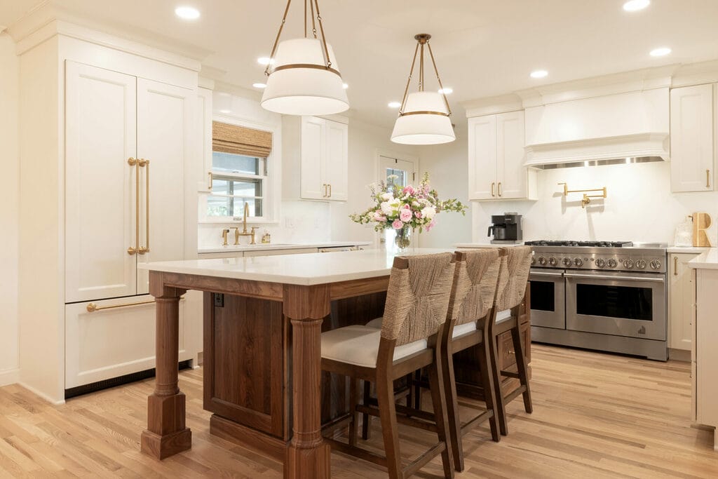 Bright white kitchen with wooden island and bar stools