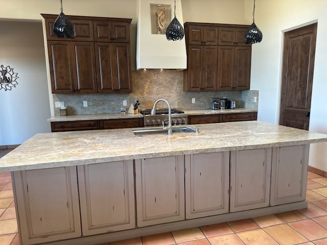 Spacious kitchen with large granite island and dark cabinets